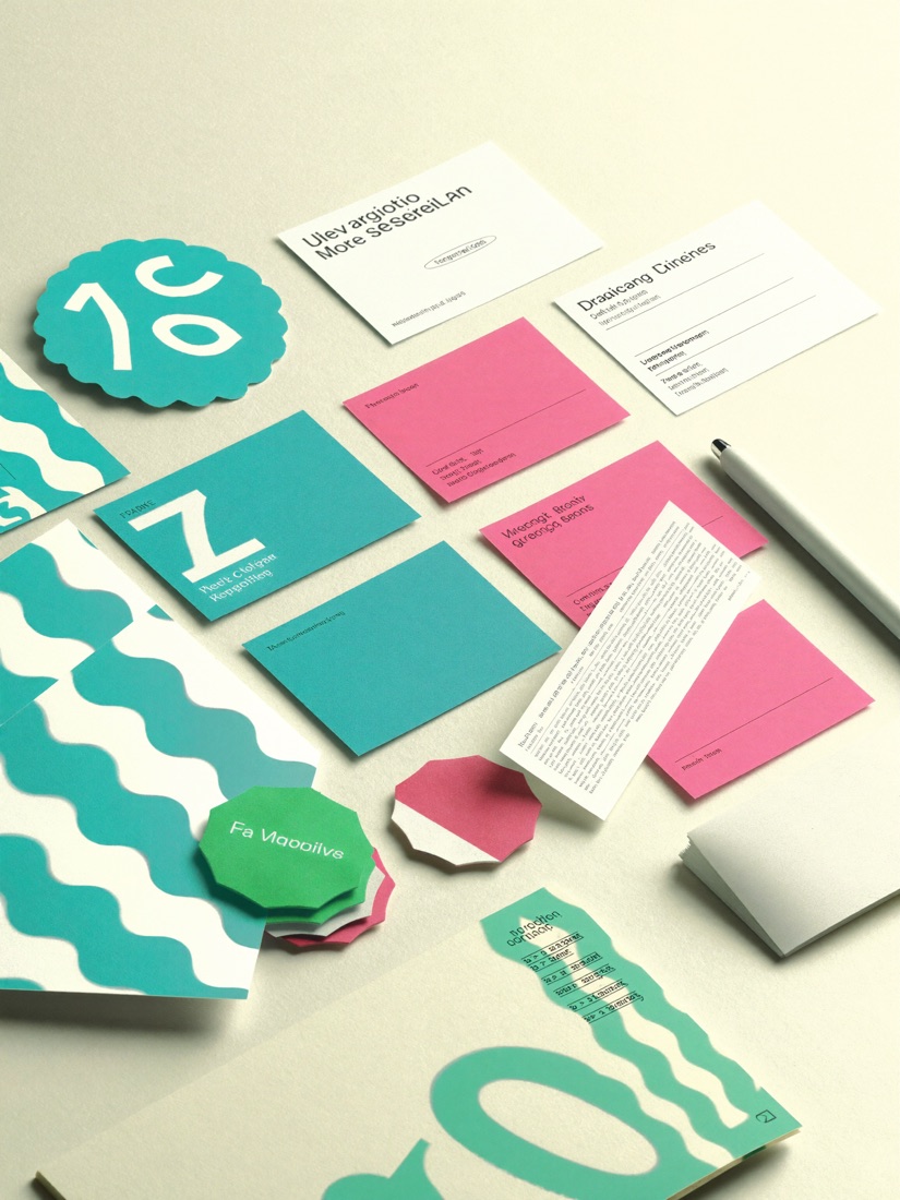 Brand identity kit flat-lay — business cards, colour swatches and logo marks in teal and pink on cream